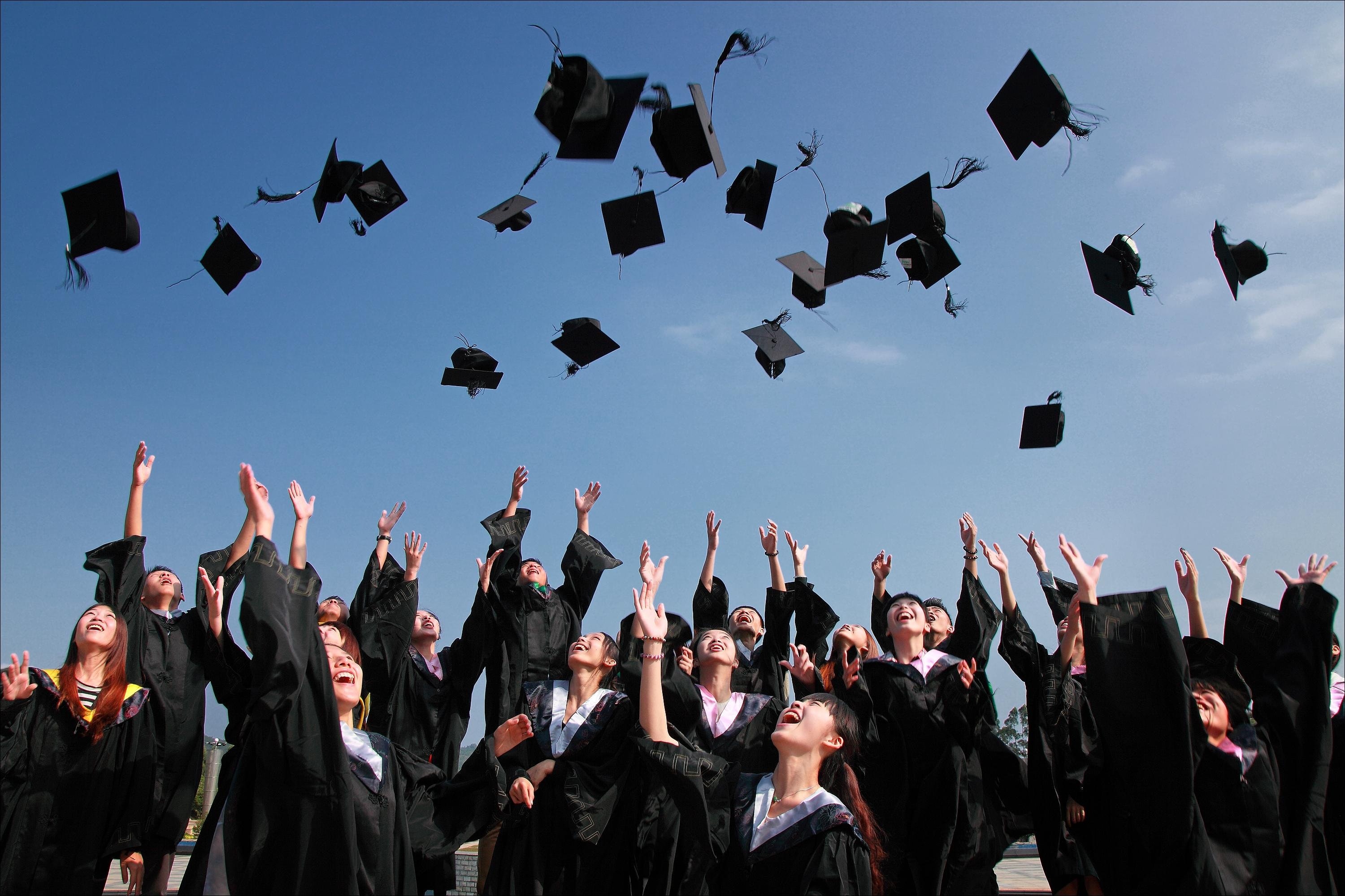 Students throwing caps from graduation into air.